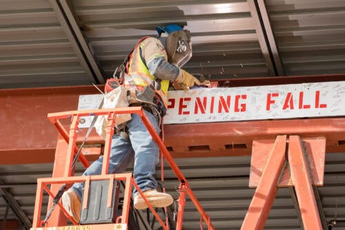 A welder affixing the truss sign. 