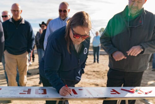 Nikki Simmons signing the truss. 