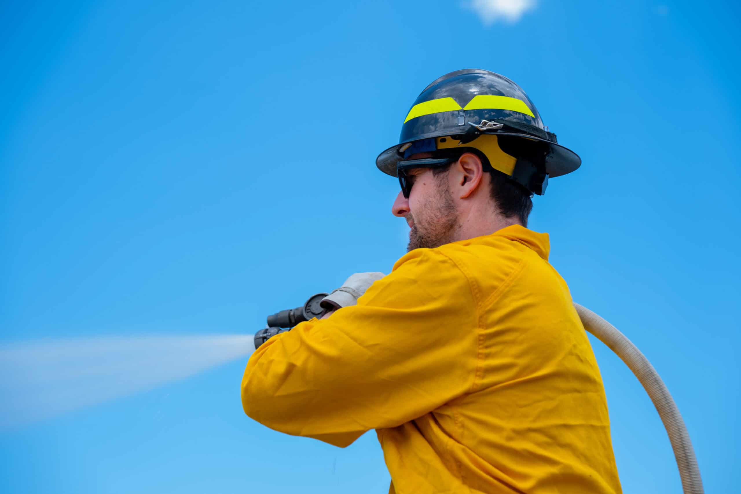 A EPSO Wildland Firefighter with a large hose apparatus.